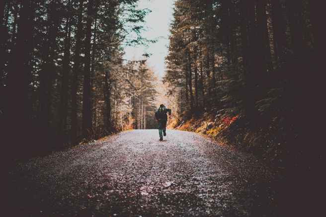 photo of person running on dirt road
